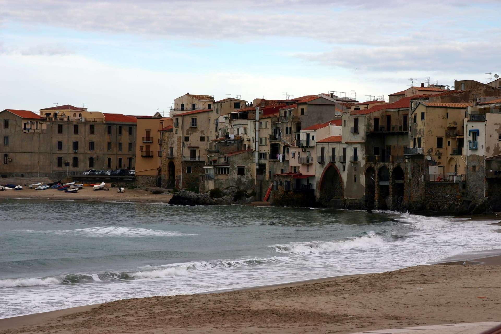 Front de mer de Cefalù en Sicile, avec maisons anciennes au bord de l’eau